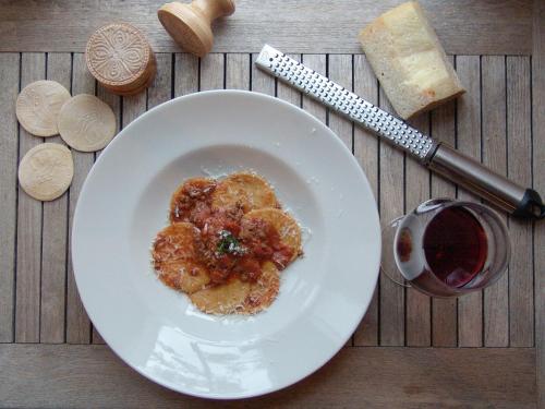 a white bowl of food and a glass of wine at La Sosta di Ottone III in Levanto