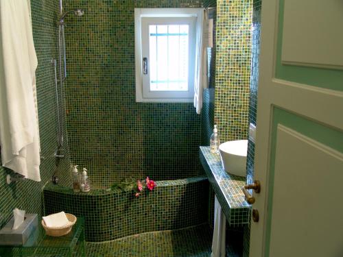 a green tiled bathroom with a sink and a shower at La Sosta di Ottone III in Levanto