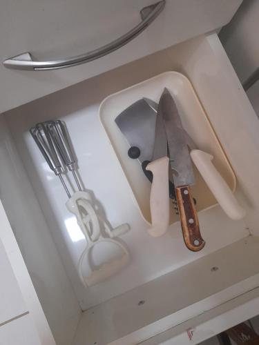 a knife and other kitchen utensils in a drawer at Apartamento Inteiro em Setor Nobre in Goiânia