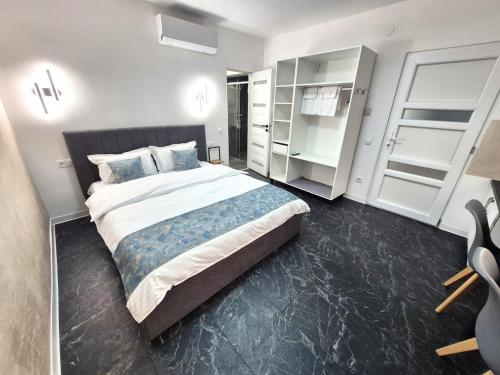 a bedroom with a large bed and white cabinets at Central Suites Targu Mures in Târgu-Mureş