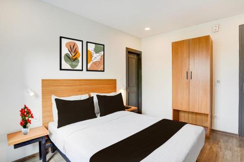 a bedroom with a large bed with a wooden headboard at OYO Townhouse Deva Road Lucknow in Lucknow