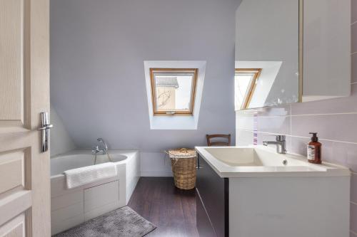 a white bathroom with a sink and a tub at Maison Ferrer - avec jardin clos in Villeneuve-le-Roi