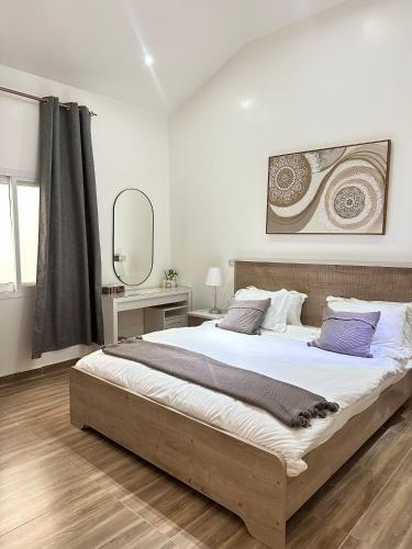 a bedroom with a large bed and a mirror at Wadi Bani Khalid - Al Joud Green Hostel in Zilaft