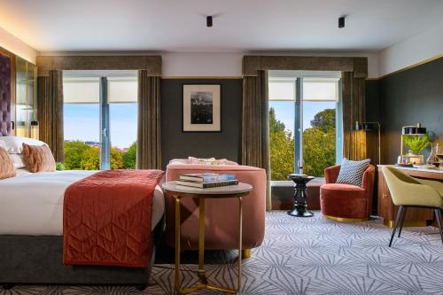a hotel room with a bed and a desk at The Fitzwilliam Hotel in Dublin