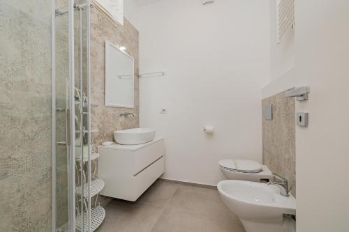 a white bathroom with a sink and a toilet at La casa di Gaia in Como