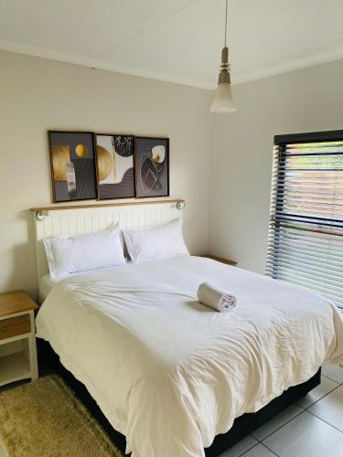 a bedroom with a large white bed with white sheets at The blyde 1 bedroom in Pretoria