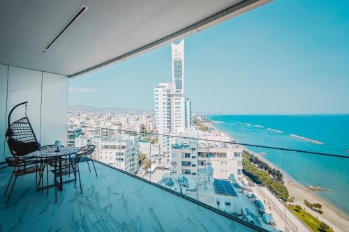 a balcony with a table and chairs and the ocean at Stunning 1 Bed in Trilogy, Limassol Seafront in Limassol