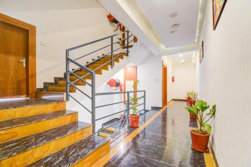 a hallway with stairs and potted plants at Palette by CheckIn Goverdhan Villas Formerly The White Fresco in Udaipur