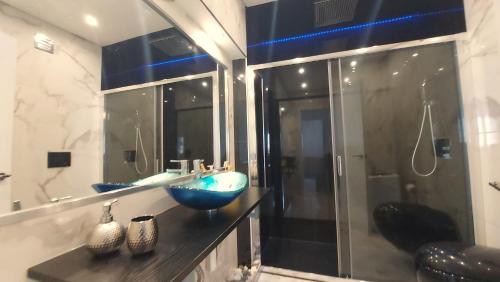 a bathroom with a blue bowl sink and a shower at AL Sunset in Albufeira