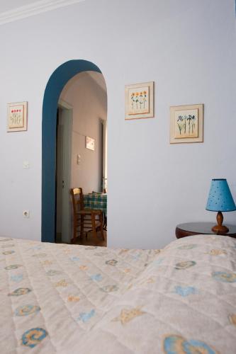 a bedroom with a bed and a table with a lamp at Zorbas Apartments in Volissos