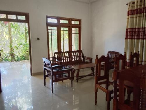 a living room with chairs and a table and a window at Tha Ivory villa in Nattarampota