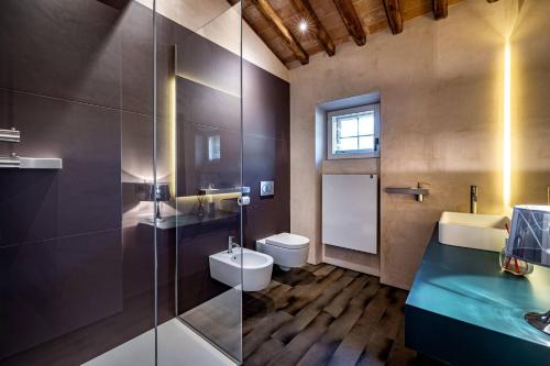 a bathroom with a toilet and a glass shower at YD exclusive design villa Agati in Castiglion Fiorentino