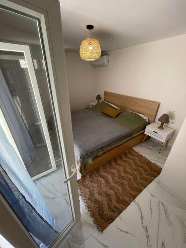 a small bedroom with a bed and a glass door at Lemon tree Gr in Xylokastro