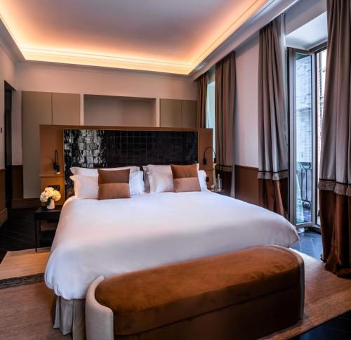 a bedroom with a large white bed and a large window at Serras Sevilla in Seville
