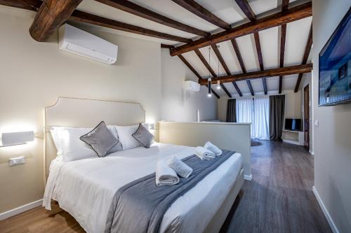 a bedroom with a white bed with towels on it at Garibaldi Luxury apartments in Prato
