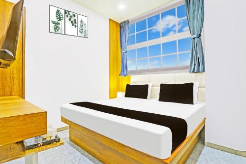 a bedroom with a white bed and a window at Super Collection O Adajan Formerly Hotel Western Inn in Surat