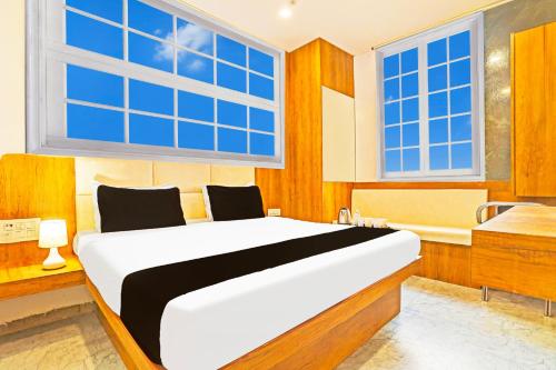 a bedroom with a large bed and a bath tub at Super Collection O Adajan Formerly Hotel Western Inn in Surat