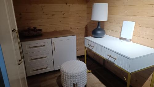 a room with a desk with a lamp and a stool at Domek Dolina Żurawia in Borzynowo