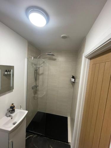 a bathroom with a shower and a sink at Hillcrest House Holiday Suites in Donegal