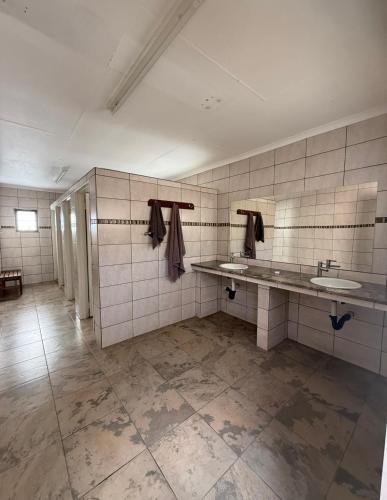 a bathroom with two sinks and two mirrors at East Gate Rest Camp in Buitepos