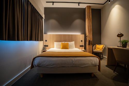 a hotel room with a bed and a desk and a bed sidx sidx at Hôtel & Restaurant Five Nations in Durbuy
