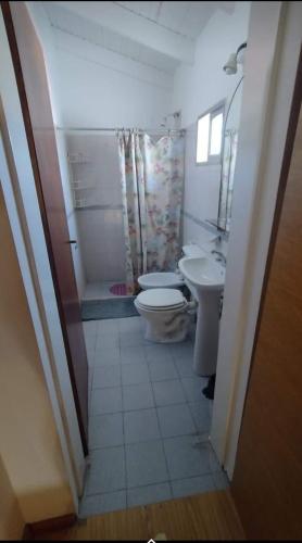 a bathroom with two toilets and a sink at Complejo el Cuy in Las Grutas