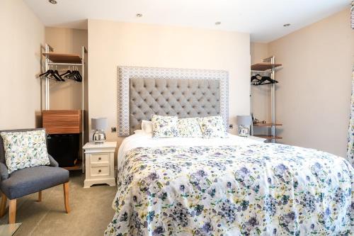 ein Schlafzimmer mit einem großen Bett und einem Stuhl in der Unterkunft Cherry Tree in Horbury