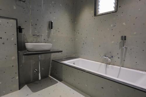 a bathroom with a bath tub and a sink at Srushti Resort in Daulatābād