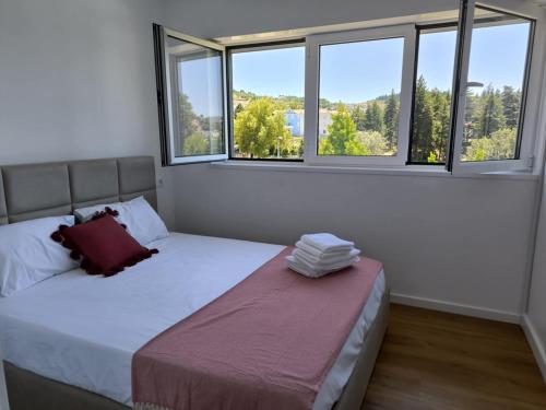 a bedroom with two beds and two windows at Loreto Apartment in Bragança