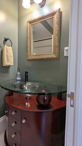 a bathroom with a glass sink and a mirror at Rose & Thistle B&B Lunenburg in Lunenburg