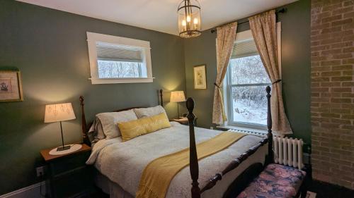 a bedroom with a bed and two windows at Rose & Thistle B&B Lunenburg in Lunenburg