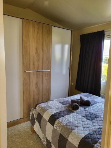 a bedroom with a bed and a large window at Chalet in menaam in Dronrijp