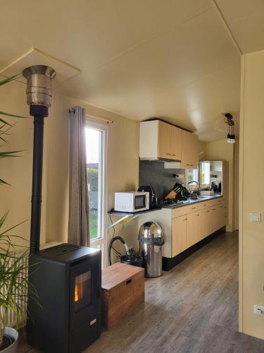 a kitchen with a stove in the middle of a room at Chalet in menaam in Dronrijp