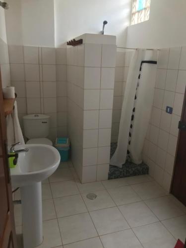 a bathroom with a sink and a shower and a toilet at Maio Relax in Vila do Porto