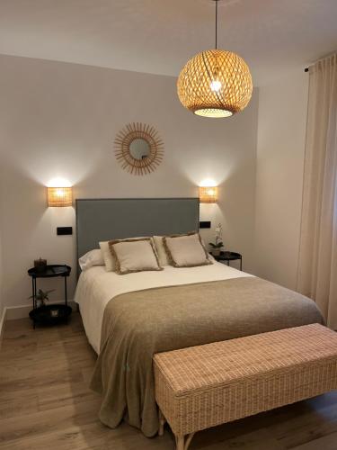 a bedroom with a large bed and a chandelier at Los Cucos in Cabezuela del Valle
