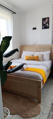 a bedroom with a bed with yellow and white sheets at Zangem BnBs in Ruiru