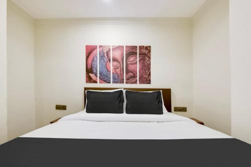 a bedroom with a large white bed with two pillows at Super Hotel O Dabolim Near Goa International Airport in Goa