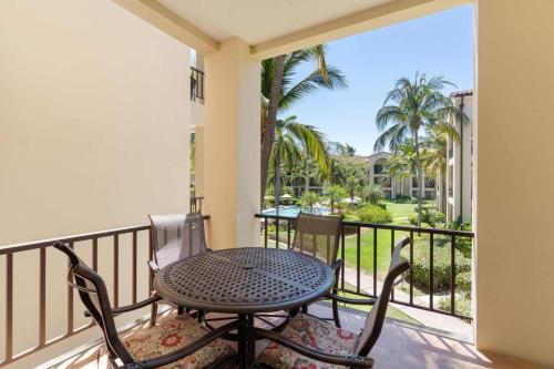 a patio with a table and chairs on a balcony at Vibrant 3-Bedroom Condo with Resort Amenities, Pools & Beach Club Access in Coco
