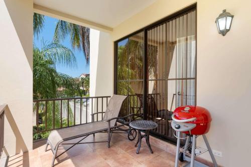 a balcony with a chair and a table and a stool at Vibrant 3-Bedroom Condo with Resort Amenities, Pools & Beach Club Access in Coco