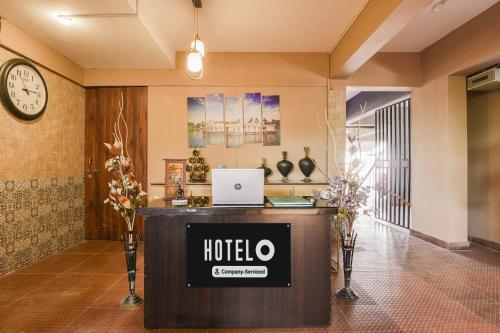 a hotel lobby with a desk with a laptop on it at Super Hotel O Dabolim Near Goa International Airport in Goa