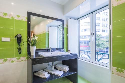 bagno con lavandino e finestra di Vila Nova Guesthouse a Lisbona