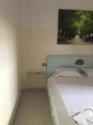 a bedroom with a bed and a painting on the wall at Maio Relax in Vila do Porto