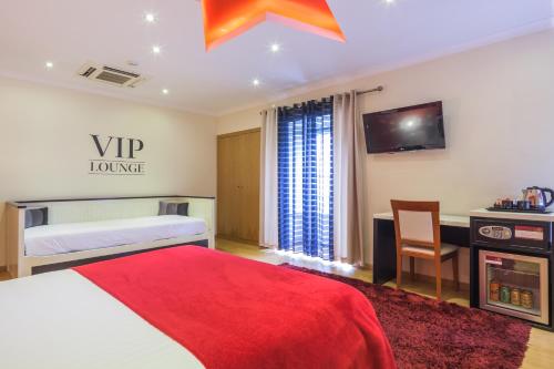 a bedroom with a bed and a desk and a tv at Vila Nova Guesthouse in Lisbon