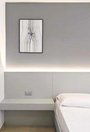 a bedroom with a bed and a picture on the wall at The Superhost - IL Lux in Crotone