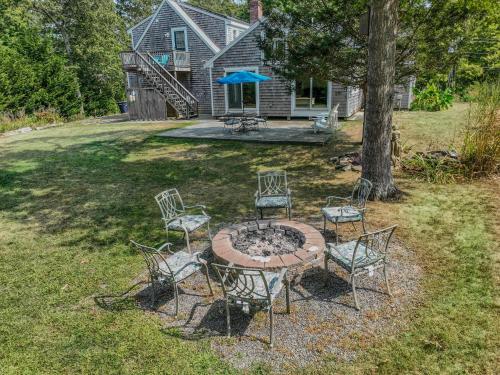 a group of chairs sitting around a table in a yard at Beautiful Property w Separate Apartment in Brewster