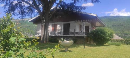 a white house with a tree in the yard at Charming house with great views in Brison-Saint-Innocent