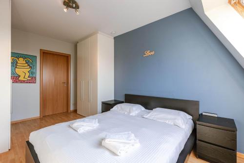 a bedroom with a large bed with white sheets at Casiola - Comfortable Apartment with Scenic Views in De Haan