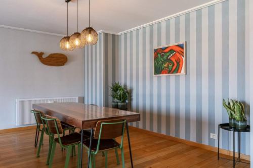 a dining room with a wooden table and chairs at Casiola - Comfortable Apartment with Scenic Views in De Haan