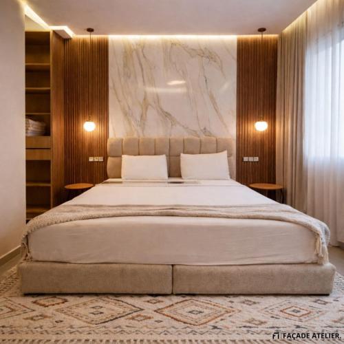 a bedroom with a large bed with a marble wall at Le Calme a Temara in Temara