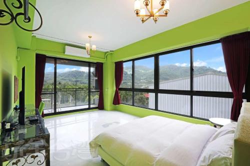 a green bedroom with a bed and large windows at Mao Lan Mountain Holiday Villa in Shan-tzu-chiao
